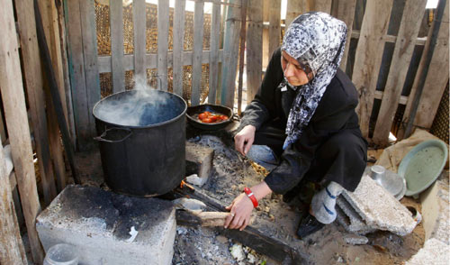 امرأة فلسطينيّة تطبخ لعائلتها في بيت لاهيا شمال قطاع غزة أمس (حاتم موسى - أ ب)