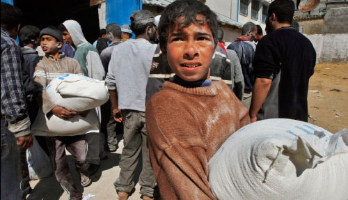 فلسطينيون يحملون أكياساً من الطحين في غزة أمس (خليل حمرا - أ ب)