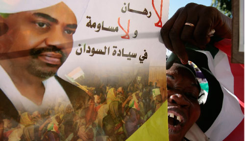 متظاهر يحمل صورة البشير في الخرطوم أمس (زهرا بنسيمرا - رويترز)