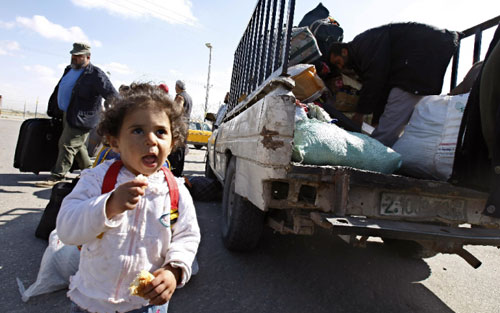 طفلة فلسطينية تنتظر وعائلتها للعبور إلى معبر رفح أمس (سعيد خطيب - أ ف ب)