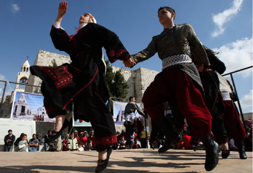 فلسطينيون يؤدّون رقصة فولكلورية للمناسبة في بيت لحم (نايف هشلمون ـــ رويترز)
