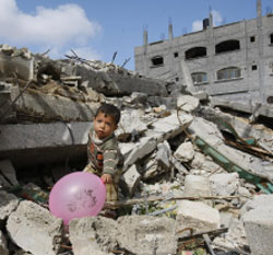 طفل فلسطيني يلعب فوق أنقاض بيته في غزة أمس (محمد عبد - أ ف ب)