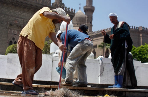 عمال مصريون ينظفون ساحتي مسجدي السلطان حسن والرفاعي لاستقبال الرئيس الأميركي في القاهرة أمس (عمرو نبيل - أ ب)