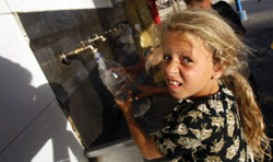 طفلة فلسطينية تملأ زجاجتها بالماء في جنوب غزة أمس (محمود حمص - أ ف ب)