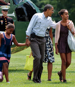 اوباما مخاطباً ماليا وإلى جانبه ساشا بعد عودة العائلة الأولى من عطلتها في ماين الشهر الماضي (مانويل بالشي سينيتا ــ أ ب)