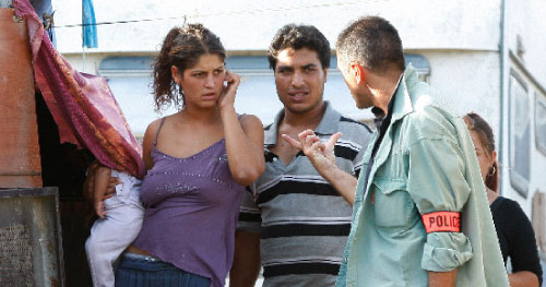 أسرة من الغجر تتجادل مع شرطي فرنسي حول قرار الترحيل (فيليب لوريسون ــ رويترز)