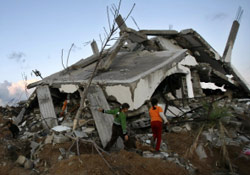 فلسطينيات يمشين على حطام منزلهن في غزة امس (محمود حمص - أ ف ب)