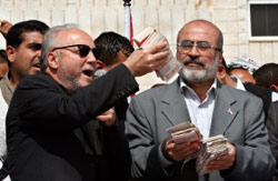 غالاوي يقدم الأموال لوزير المال في الحكومة المقالة في غزة أمس (حاتم موسى ــ أ ب)