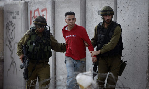 جنديان إسرائيليان يعتقلان فلسطينياً حاول الوصول إلى المسجد الأقصى أمس (ديفيد فرست - أ ف ب)