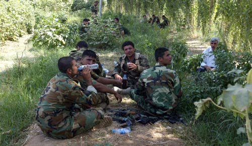 جنود أكراد يجلسون بين الأشجار في بلدة خانقين في أيلول الماضي (علي يوسف - أ ف ب)