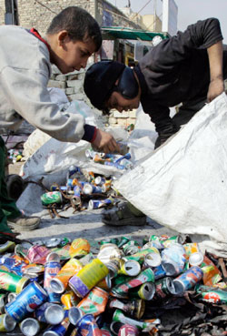 مراهقان عراقيان يبحثان في القمامة في شوارع بغداد (كريم كاظم ــ أ ب)