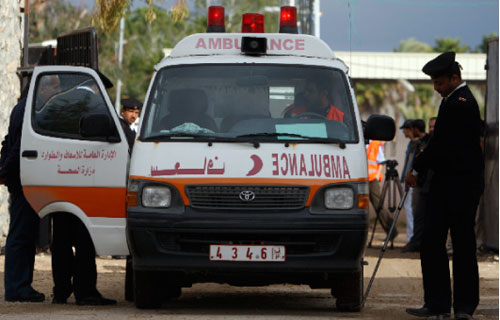 رجال أمن مصريّون يفتّشون سيارة إسعاف تنقل جرحى فلسطينيين إلى أحد مستشفيات مصر عند معبر رفح (عمرو دلش ــ رويترز) 