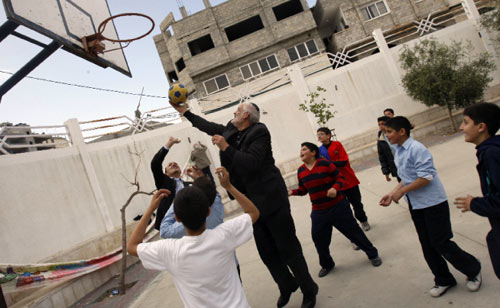 حاخام يهودي يلعب كرة السلة مع أطفال فلسطينيين خلال زيارته غزة ضمن قافلة للسلام أمس (محمد عبد - أ ف ب)