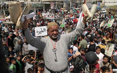 فلسطيني يحمل صك ملكية منزله ومفتاحه خلال تظاهرة بذكرى النكبة في نابلس أمس (ماجد محمد - أ ب)