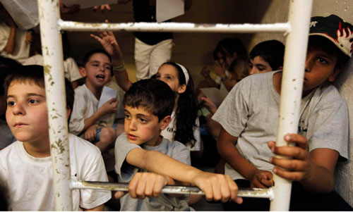 طلاب إسرائيليون يختبئون في ملجأ في القدس المحنلة أثناء المناورة أمس (أ ب)