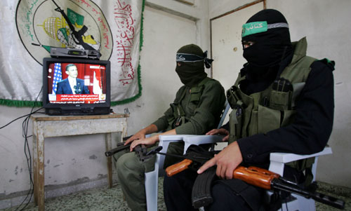 عنصران من «حماس» يستمعان إلى خطاب  اوباما في قطاع غزة أمس ( اياد بابا - أ ب)
