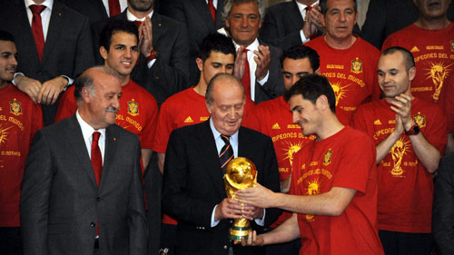 كابتن اسبانيا إيكر كاسياس يسلّم كأس العالم الى الملك خوان كارلوس تحت انظار المدرب فيسنتي دل بوسكي (دومينيك فاجيه - أ ف ب) 