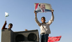 أحد مناصري المالكي يرفع صورته في الأعظمية أمس (خليل المرشدي ـــ أ ف ب)