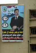 رجل يعلق صورة لمرشح سني في الرمادي امس (علي مشهداني ــ رويترز)