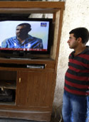 عراقي يتابع اعترافات الشخص الذي تقول الحكومة العراقية إنه أبو عمر البغدادي في بغداد أمس (أحمد الربيعي ـــ أ ف ب)