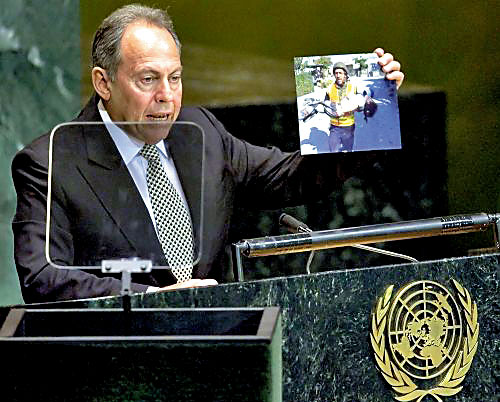 لحود يلقي كلمته في الأمم المتحدة وفي يده صورة لاحدى ضحايا مجزرة قانا