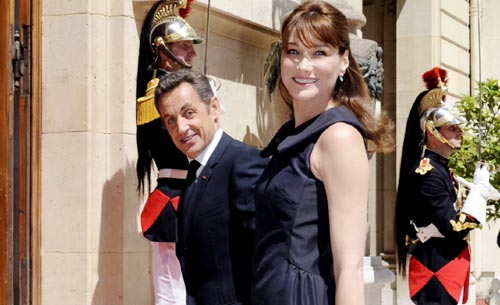 ساركوزي وكارلا بروني لدى توجّههما إلى ساحة العرض العسكري (ستيفان دي ساكتين ـ أ ب)
