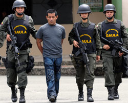 جنود كولومبيون يعتقلون أحد عناصر «الفارك» (لويس بينافيدس - أ ب)