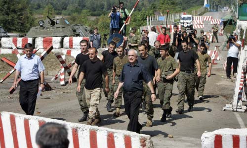 مسؤولون جورجيون يرافقون 12 جندياً بعد إطلاقهم من إقليم أبخازيا أمس (سيرغي غيرتس - أ ب)