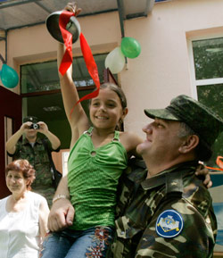 جندي روسي يحمل فتاة أوسيتية في تسخينفالي أمس (ديمتري لوفيتسكي ــ أ ب)