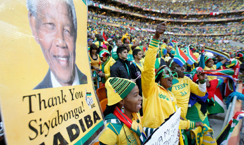 جنوب افريقيون في المدرجات مع صورة لمانديلا خلال حفل الافتتاح (سيفيوي سيبيكو ــ رويترز)