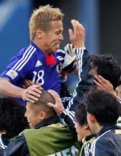 بدلاء المنتخب الياباني يحتفلون بزميلهم هوندا بعد تسجيله هدفه (أوجين هوشيكو ــ أ ب)