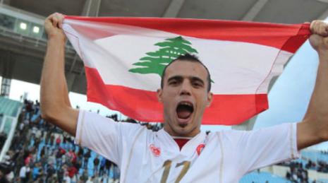 محمود العلي رافعاً العلم اللبناني