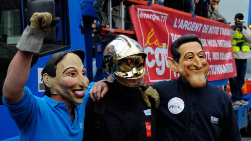 متظاهرون يرتدون أقنعة لساركوزي ورويال في باريس أول من أمس (فيليب ووجازر - رويترز)