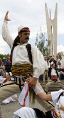 رقصة ترحيب بالضيف الأميركي على الطريقة الألبانية أمام مقر البرلمان في بريشتينا أمس (هزير ركا - رويترز)