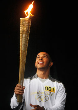 هاميلتون حاملاً الشعلة الأولمبية في لوتون أول من أمس (رويترز)