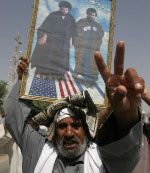 عراقي يحمل صورة حسن نصر الله ومقتدى الصدر في بغداد (علاء المرجاني ـــ أ ب)