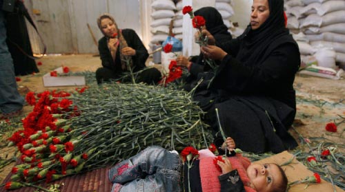 نساء غزّة يجهّزن وروداً حمراء للتصدير إلى أوروبا (ابراهيم أبو مصطفى ــ رويترز)