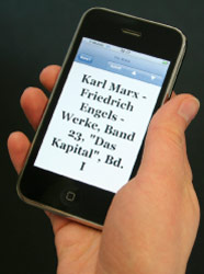 كارل ماركس وفريديريك إنغلز و«رأس المال» على شاشة هاتف مواطنة ألمانية (جوشن كروس ـــ أ ب)