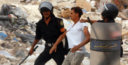 عنصرا أمن مصريان يعتقلان متظاهراً في منشية ناصر في القاهرة أول من أمس (رويترز)