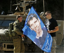 إسرائيلي يحمل صورة إلداد ريغيف في ذكرى حرب تمّوز (سيباستيان شاينر ــ أ ب)