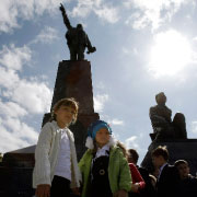 أوكرانيون أمام تمثال لينين على البحر الأسود (رويترز)