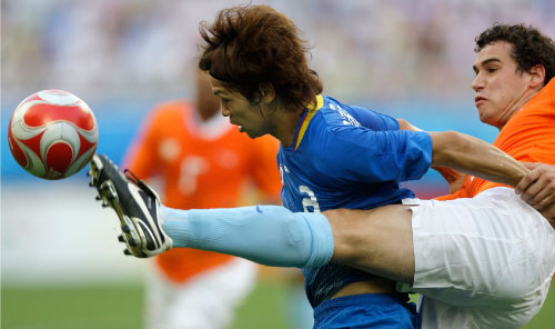 الهولندي مارسيليس يبعد الكرة من أمام الياباني موريشيغي (روبرتو كانديا ـ أ ب)