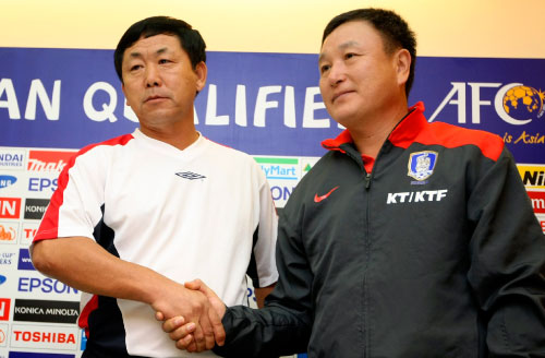المدربان الكوريان، الشمالي يونغ هون، والجنوبي جونغ مو، يتصافحان خلال المؤتمر الصحافي (اوغين هوشيكو ـ أ ب)