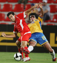 لاعب العربي بيسكوليتشي يحمي الكرة من نشأت أكرم (25) (ف. الأسعد ـ رويترز)
