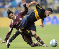 سباق عنيف على الكرة بين مهاجم بوكا شافيز ولاعب لانوس غريب (دانييل لونا ـ أ ب)