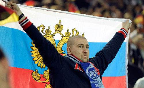 مشجّع روسي يحمل علم بلاده ويزيّن رقبته بوشاح فريق زينيت سان بطرسبورغ، خلال مباراة ألمانيا وروسيا الأخيرة في تصفيات مونديال 2010 (مارتن مايسنر ــ أ ب)