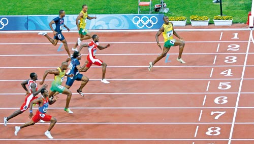 إحدى أبرز لقطات سنة 2008: العداء الجامايكي أوساين بولت متفوّقاً على منافسيه ومحتفلاً بطريقة استعراضية قبل عبوره خط النهاية لسباق 100 م في أولمبياد بكين (أرشيف)