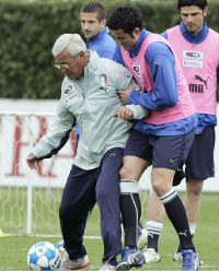 لاعب المنتخب الإيطالي فابيو غروسو يحاول انتزاع الكرة من مدربه مارتشيلو ليبي (فابريتسيو جوفانوتزي ــ أ ب)