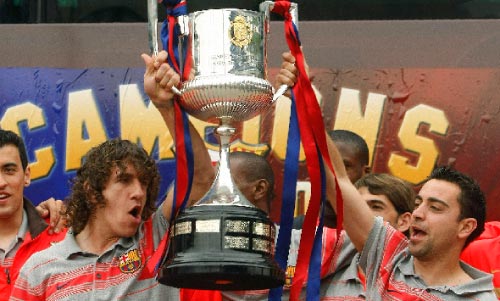 شافي (إلى اليمين) وبويول يرفعان كأس إسبانيا أمام جمهور الفريق في «نو كامب» أمس (ألبرت جيا ـ رويترز)
