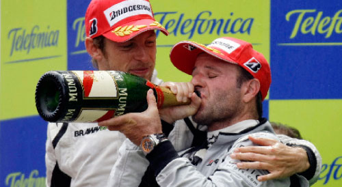 روبنز باريكيللو يحتسي الشامبانيا تحت أنظار زميله جنسون باتون الفائز بالمركز الأول في جائزة إسبانيا (داني كاردونا ـ رويترز)